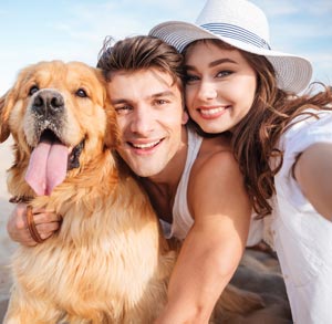 Picture of of a man and woman with their dog outside
