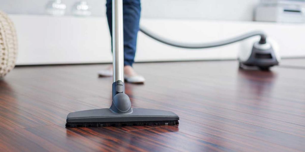 Picture of person vacuuming a hardwood floor