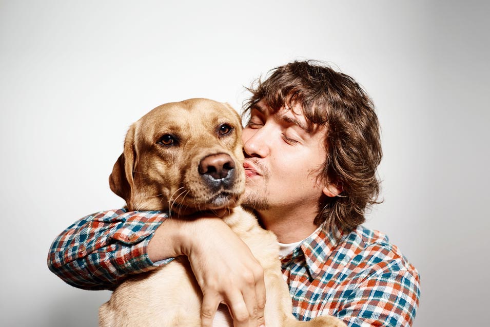 Picture of of a man kissing his dog