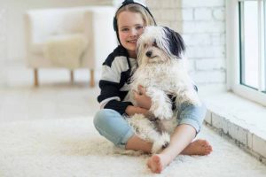 Picture of young girl holding a Havanese puppy