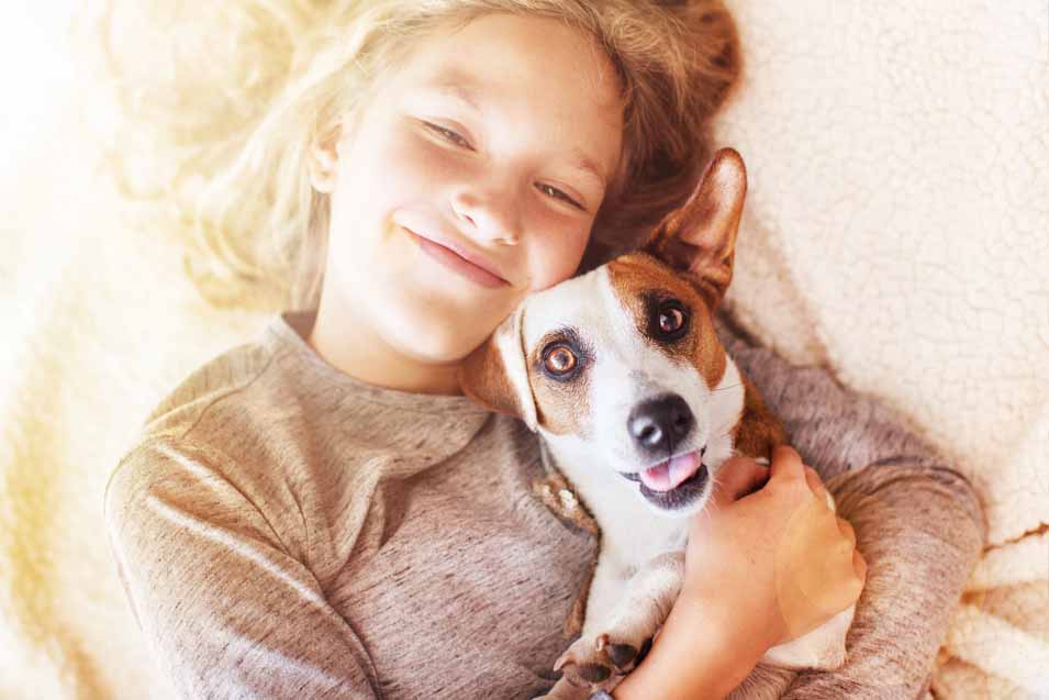 Picture of girl snuggling with at dog