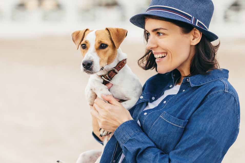 Picture of a woman in blue coat holding a dog