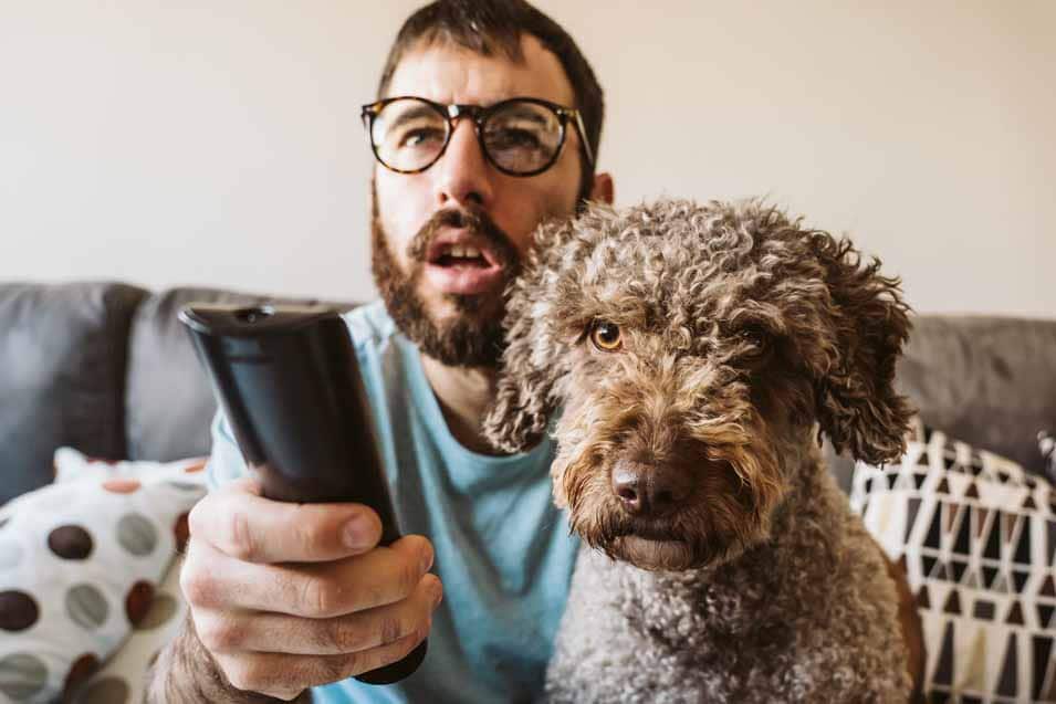Picture of a man watching tv with his dog