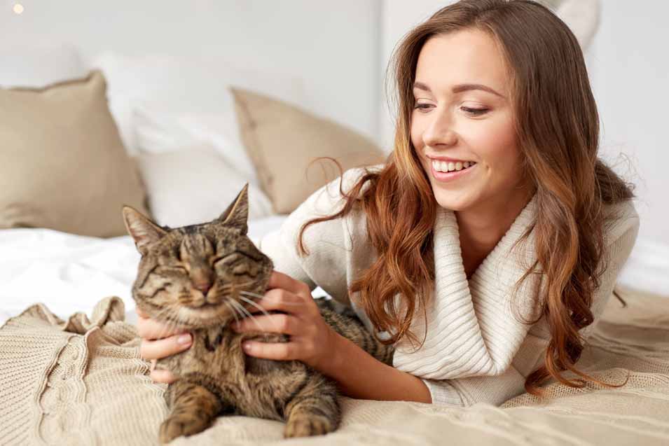 Picture of a woman and a cat on a bed