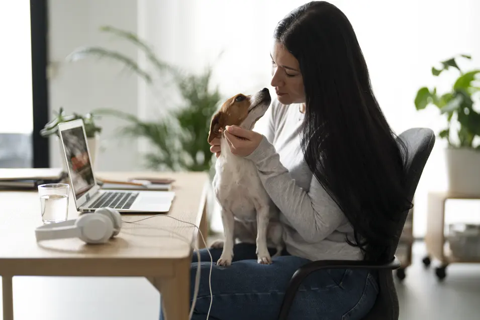 woman petting dog at her desk