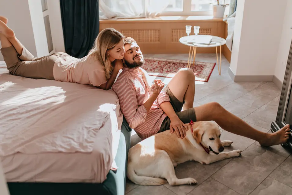 couple and dog in the bedroom